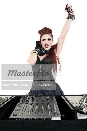 Portrait of punk DJ with arm raised over white background