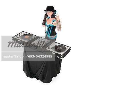 Portrait of female DJ gesturing rock sign over white background