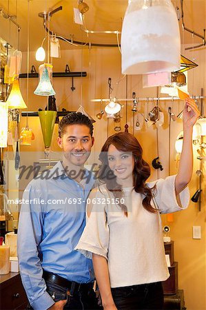 Portrait of a happy young couple with price tag in lights store