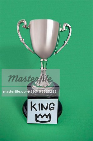 Trophy with sticky note over colored background