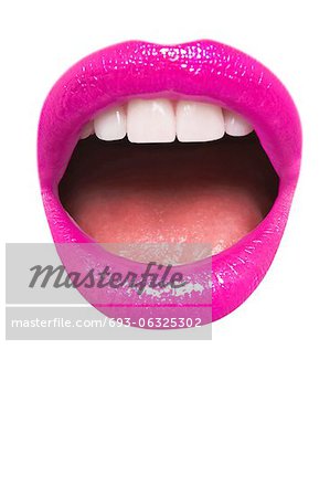 Close-up view of female wearing pink lipstick with mouth open over white background