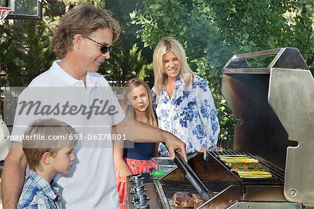 Family of four barbecuing