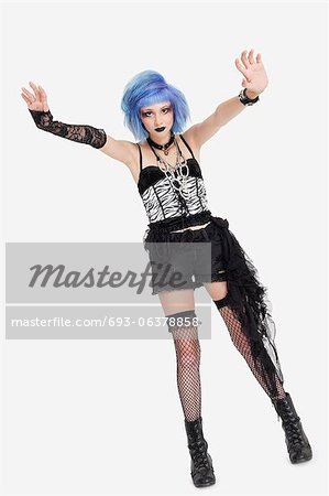 Portrait of young female punk hand gesturing over gray background