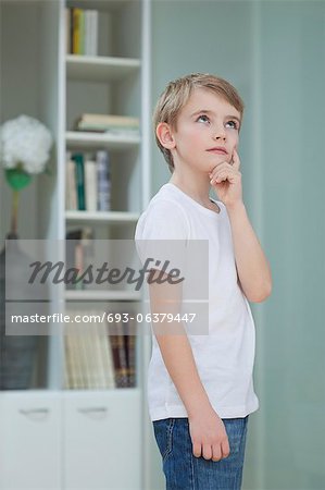 Little boy lost in thoughts at home