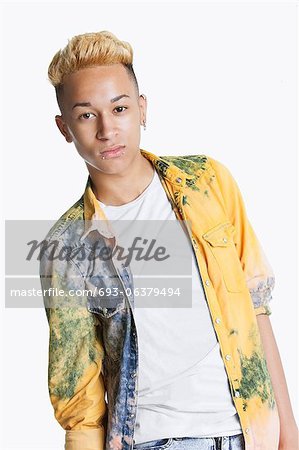 Portrait of a teenage boy with blond hair over gray background