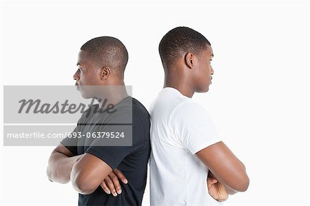 Two male friends standing back to back over gray background