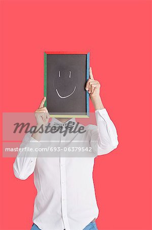 Man holding smiley face sign over red background