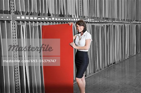 Portrait of mid adult businesswoman holding thin red veneer sheet