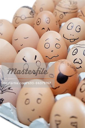 Anthropomorphic brown eggs arranged in carton against white background