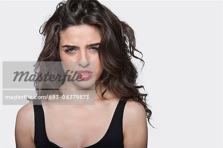 Portrait of a frustrated young female against gray background