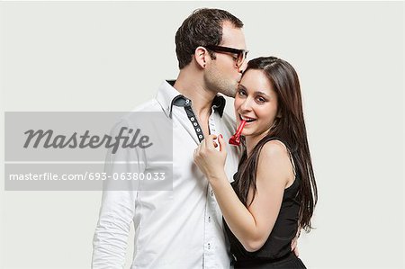 Young couple with party puffer against gray background