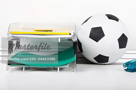 Soccer ball near file rack at desk