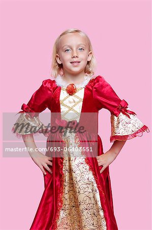 Portrait of a happy young girl dressed in princess costume over pink background
