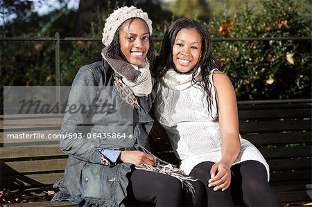 Portrait of young women relaxing on park bench