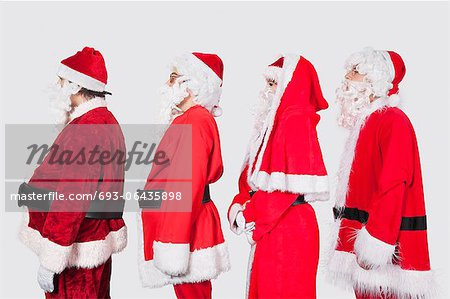 People in Santa costume standing in row against gray background