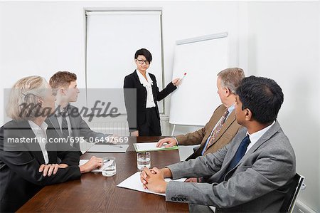 Young woman using whiteboard in business meeting