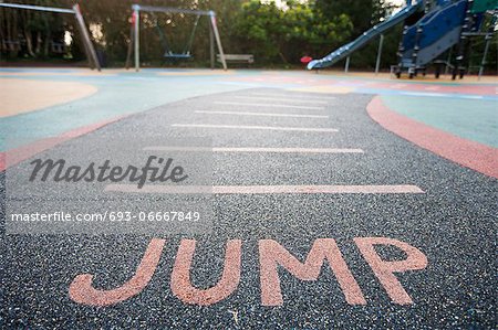 Jump written into rubber floor of playground