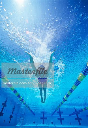 Full length of female swimmer in United States swimsuit swimming in pool