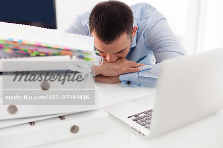 Close-up view of Caucasian businessman asleep at his desk