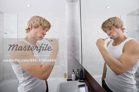 Man brushing teeth in bathroom