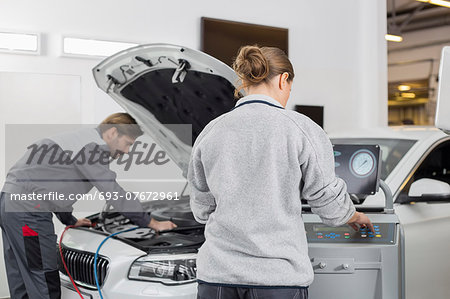 Automobile mechanics working in automobile repair shop Automobile mechanics working in automobile repair shop