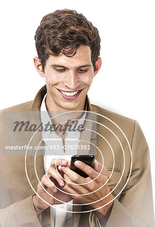 Smiling young businessman using cell phone over white background
