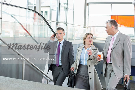 Businesspeople walking up stairs in train station
