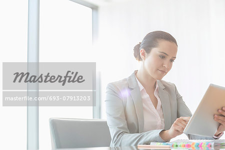 Young businesswoman using digital tablet in office