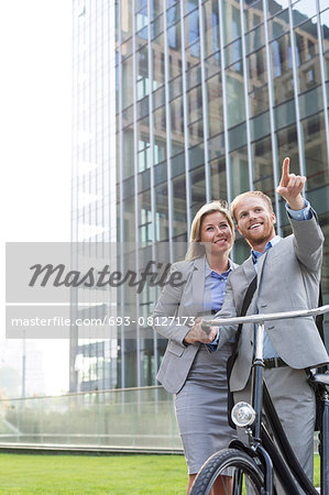 Happy businessman showing something to businesswoman in city