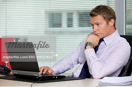 Businessman sitting with laptop at office