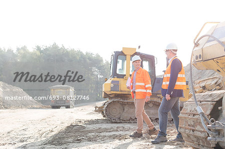 Supervisors walking at construction site against clear sky