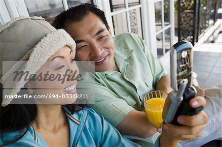 Couple using mobile phone on porch