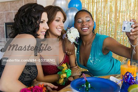 Well-dressed teenage girls taking picture at school dance