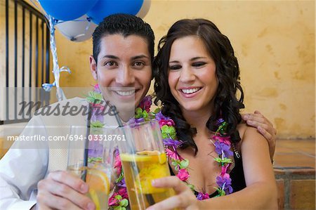 Well-dressed teenage couple toasting drinks outside school dance