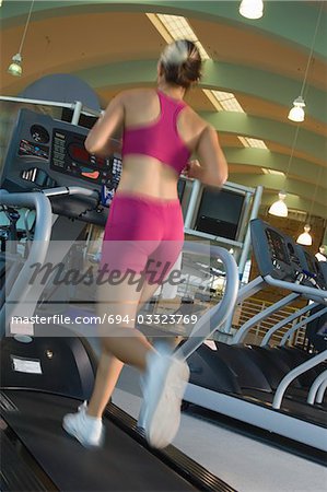 Woman Jogging on Treadmill at Gym