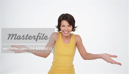 Enthusiastic woman smiling big, arms stretched out in front, palms