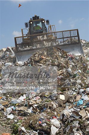 Digger working at landfill site