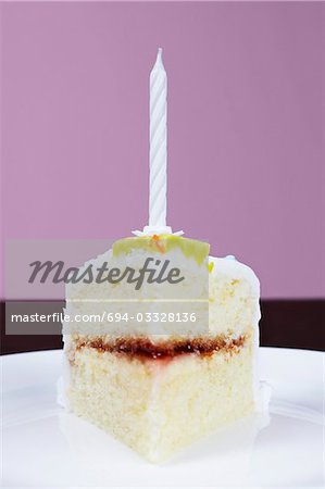 Slice of cake with birthday candle, close-up