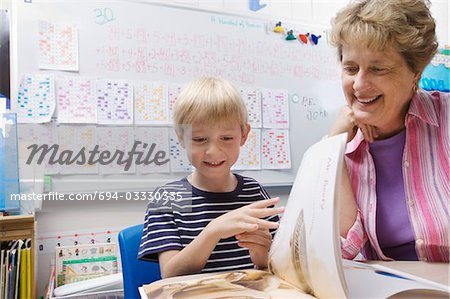 Teacher and Little Boy Looking at Book