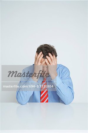 Studio shot of businessman with head in hands