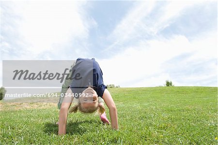 Bending over backwards, girl on grass