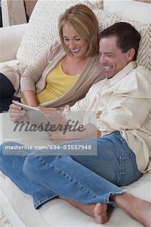 Couple sit reading a digital book