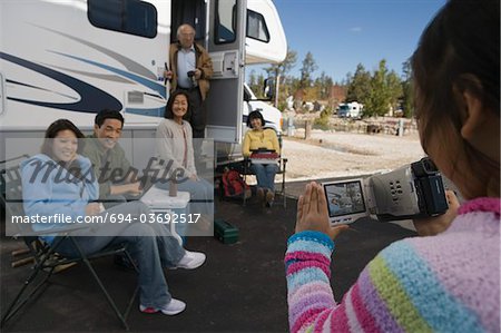 Girl videotaping family outside of RV