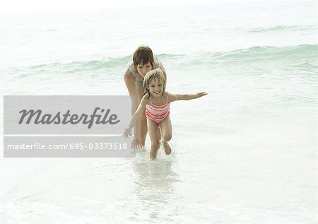 Mother and daughter in water at beach