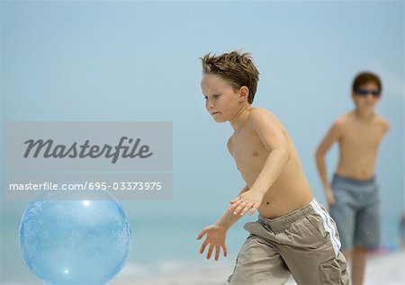 Boy catching ball on beach