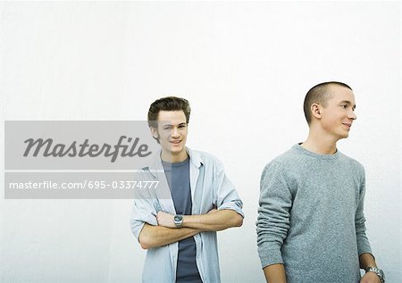 Two young adult men, one looking at camera, the other looking away