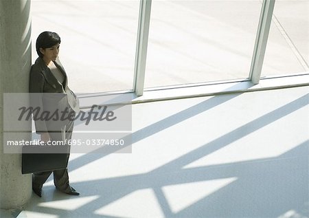 Businesswoman leaning against column, high angle view