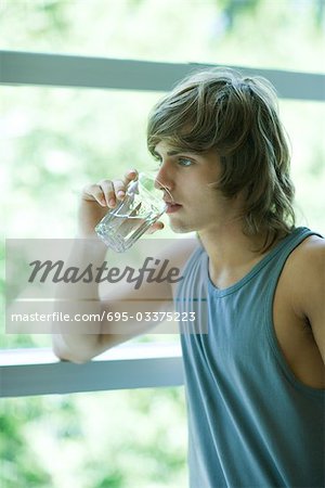 Young woman in exercise clothes drinking glass of water