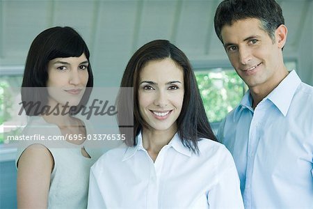 Business team smiling at camera, head and shoulders, portrait