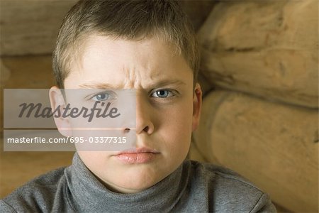 Boy frowning at camera, portrait